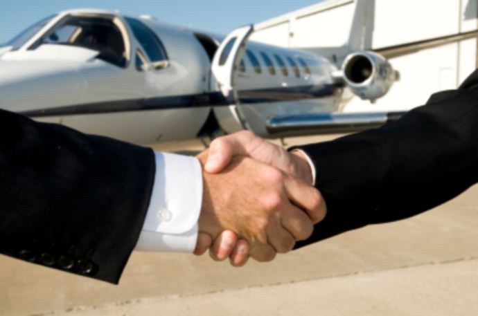 Professional handshake in front of business jet aircraft